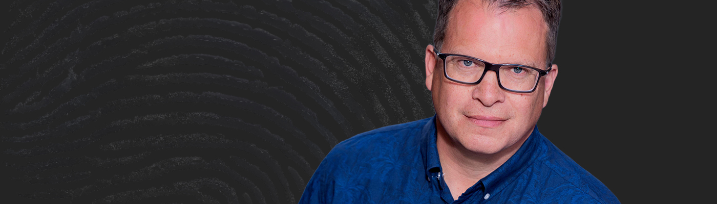 Peter Sjölund mot en mörk bakgrund med antydningar av ett fingeravtryck