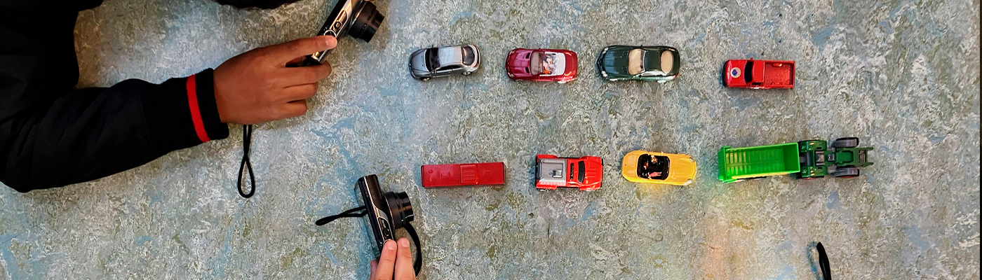 Barn som fotograferar miiatyrer av bilar